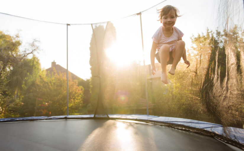 Dziecko skaczące na trampolinie ogrodowej