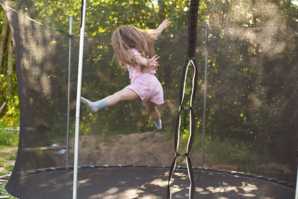 Dziewczynka na trampolinie ogrodowej